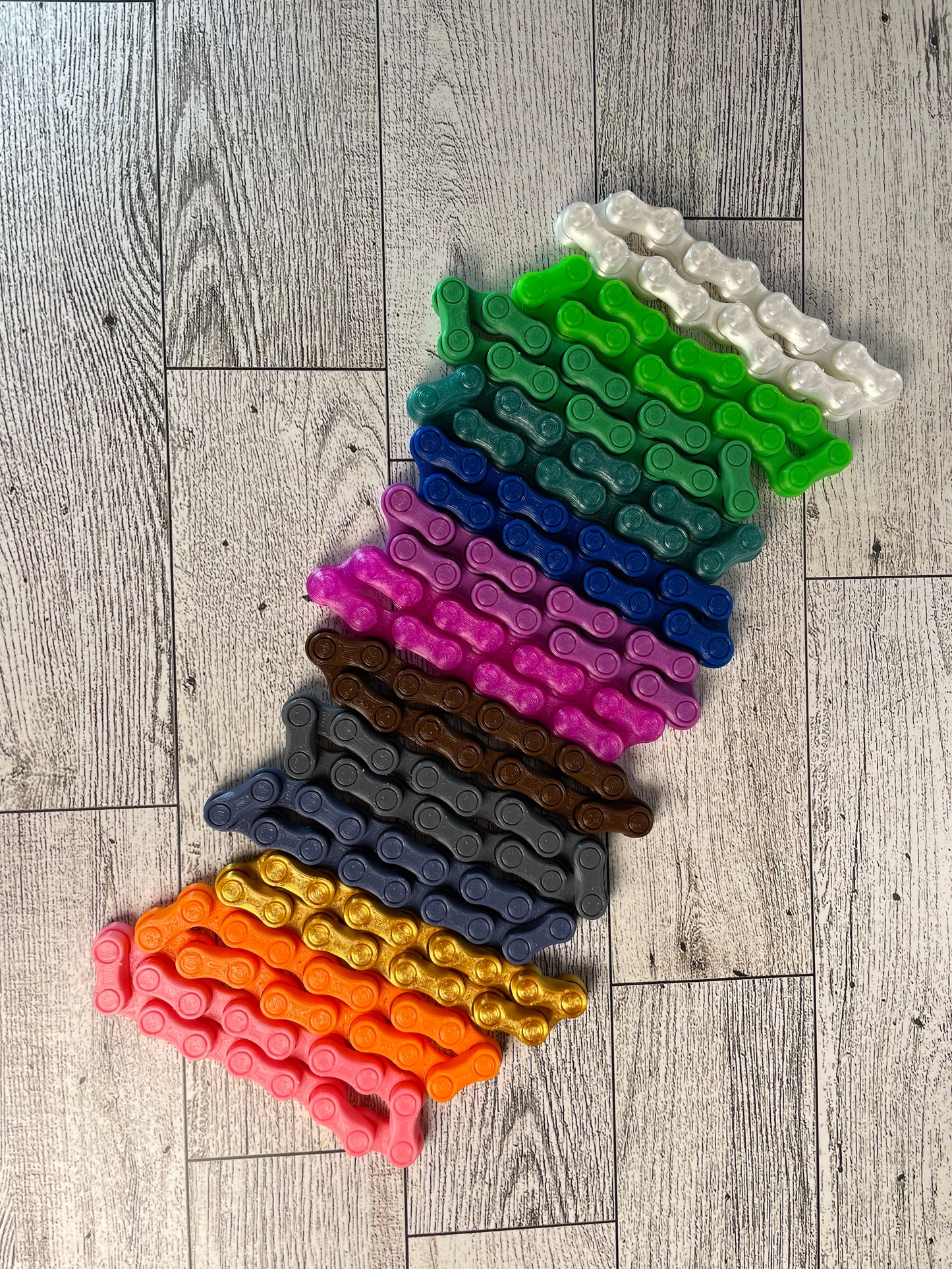 All chain link colors are lined up on a light wood grain.