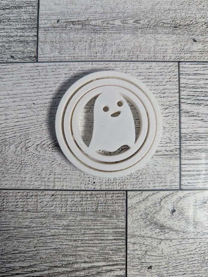 A white ghost spinner laying flat on a light wood grain.