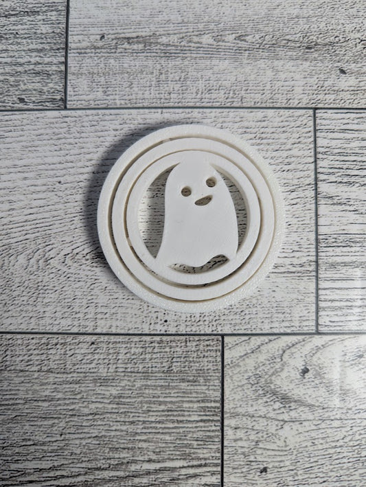 A white ghost spinner laying flat on a light wood grain.